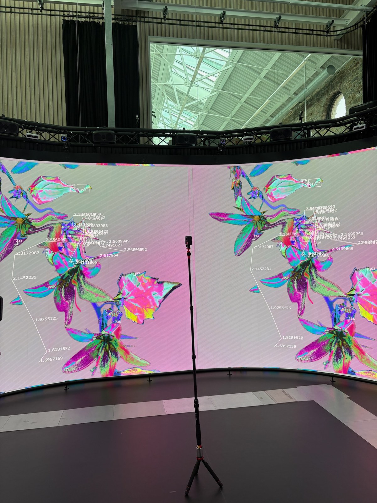 Behind-the-scenes shot of a colourful cultivation-stage visual displayed on the curved Reality Emulator screen.